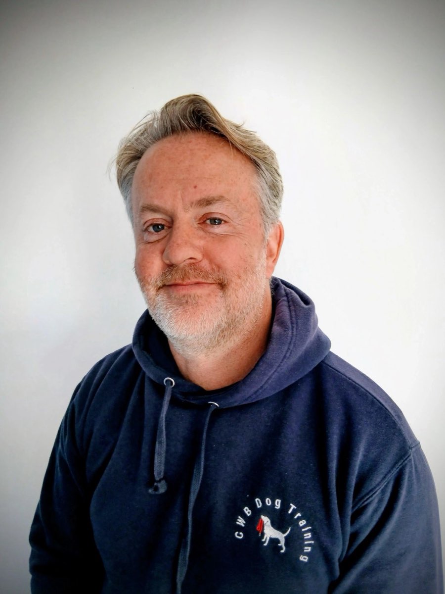 Chris, founder of CWB Dog Training, smiling in a navy CWB hoodie